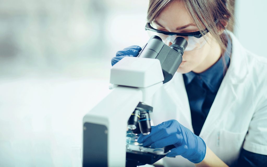 女科学家在实验室通过显微镜观察